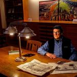 Frank Melder Jr, 77, shares what he knows about his grandfather Charles Curtiss, the National Guard lieutenant killed in the Everett Massacre, and what became of his grandmother after the Nov. 5, 1916, shootings. In the background is Camano Island artist Jack Gunter&rsquo;s painting, &ldquo;The Everett Massacre,&rdquo; now on loan to the Everett Public Library. (Dan Bates / The Herald)