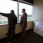 Before Sam Low&rsquo;s swearing in as a new county councilmember Tuesday, Low (right), and friend Jay Snow try to find their childhood homes from Low&rsquo;s new eighth floor office in Everett. (Andy Bronson / The Herald)