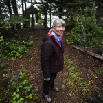 Val Schroeder stands in the wooded entrance to her home on Camano Island on Tuesday. The Snohomish Conservation District is honoring Schroeder, who started the Backyard Wildlife Habitat Project on Camano Island, with its annual Lifetime Achievement Award for her work expanding awareness on the importance of creating a healthy environment for plants and wildlife in your own yard. (Ian Terry / The Herald)