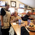 Cheri Fenstermaker (left) chats with Joan (center) and Marvin Kastning after serving them their Thanksgiving meals at The Hawks Nest restaurant in Darrington on Thursday, Nov. 24. The Hawks Nest opened their doors and served the usual Thanksgiving fanfare in a gesture to give back to the community that has welcomed them since first opening in April. (Ian Terry / The Herald)