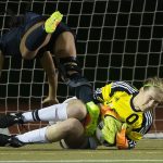 Jackson goalkeeper Kayleigh Sedlacek makes a save as Union&rsquo;s MaKayla Woods goes flying over her in Jackson&rsquo;s 2-1 win in a first-round state playoff game Tuesday at Everett Memorial Stadium. (Andy Bronson / The Herald)
