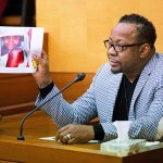 Bobby Brown holds up a picture of his daughter, Bobbi Kristina Brown, during a wrongful death case against her partner, Nick Gordon, in Atlanta, on Thursday, Nov. 17. Bobbi Kristina, the daughter of singers Brown and Whitney Houston, was found face-down and unresponsive in a bathtub in her suburban Atlanta townhome in January 2015. (AP Photo/David Goldman, Pool)