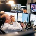 A broker reacts as U.S. President-elect Donald Trump shows up on a television screen at the stock market in Frankfurt, Germany, on Wednesday. (AP Photo/Michael Probst)