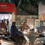 Indians crowd around an ATM machine to exchange money as a billboard displays a portrait of Indian prime minister Narendra Modi in New Delhi, India, on Tuesday. (AP Photo/Manish Swarup)