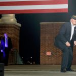 Republican presidential candidate Donald Trump ducks under a flag as he arrives to speak at a campaign rally on Wednesday in Pensacola, Florida. (AP Photo/ Evan Vucci)