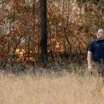Polo Gutierrez climbs onto the foundation of a destroyed home to try and see if his apartment building is still standing, Tuesday, Nov. 29, in Gatlinburg, Tennessee, after a wildfire swept through the area Monday. Gutierrez fled his apartment with other residents as fires approached the previous night. (Andrew Nelles/The Tennessean via AP)