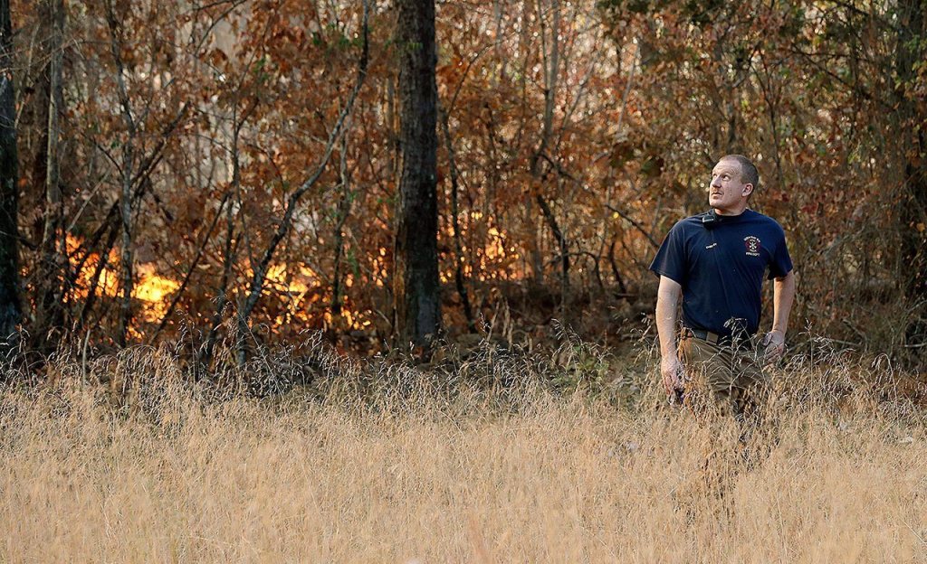 Polo Gutierrez climbs onto the foundation of a destroyed home to try and see if his apartment building is still standing, Tuesday, Nov. 29, in Gatlinburg, Tennessee, after a wildfire swept through the area Monday. Gutierrez fled his apartment with other residents as fires approached the previous night. (Andrew Nelles/The Tennessean via AP)