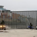 In this June 22, 2016, picture, Border Patrol agents ride all-terrain vehicles along the border structure in front of Playas de Tijuana, Mexico, in San Diego. (AP Photo/Gregory Bull)