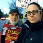 The Rev. Steven Greenebaum and Amelia Wood were among a handful of demonstrators gathered Nov. 15 at Wilcox Park in Lynnwood to protest the Dakota Access Pipeline project. The impromptu local event was for those unable to make a larger gathering in Seattle. Wood, of Everett, is a volunteer with Interfaith Association of Northwest Washington. Greenebaum leads Living Interfaith Church in Lynnwood and recently returned energized from a Nov. 3 prayer vigil at the Standing Rock Sioux reservation in North Dakota. That vigil was attended by about 500 clergy from a variety of faiths nationwide who wanted to support the tribe in its protest of the pipeline project. (Contributed photo)