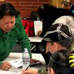 Van Dinh-Kuno (left), executive director of Refugee and Immigrant Services Northwest, answers questions about the general election ballot at an event sponsored by the Asian Pacific Islander Coalition on Friday at Everett Community College. Participants were U.S. citizens needing help from interpreters before casting their votes. (Julie Muhlstein / The Herald)