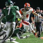 Lakes&rsquo; Cody Roe leaps a tackle attempt by Edmonds-Woodway&rsquo;s Abdoulie Jatta (bottom) with Salihou Fatty closing during a 3A playoff game Friday night at Edmonds Stadium. Lakes won 21-14. (Kevin Clark / The Herald)