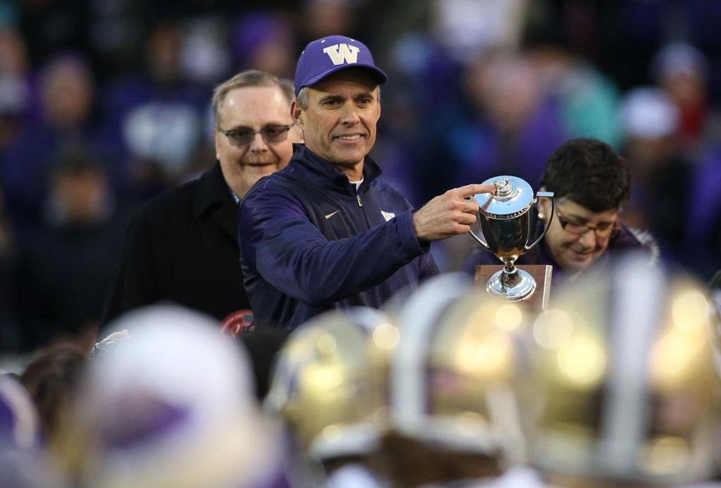 Washington head coach Chris Petersen points to a missing apple that should be atop the trophy after the Huskies beat Washington State 45-17 in the Apple Cup on Friday in Pullman. (Andy Bronson / The Herald)