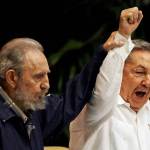 April 19, 2011: Fidel Castro (left) raises his brother&rsquo;s hand, Cuba&rsquo;s President Raul Castro, as they sing the anthem of international socialism during the 6th Communist Party Congress in Havana, Cuba. (AP Photo/Javier Galeano, File)