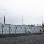A crane sits next to a row of vanadium flow batteries at the PUD&rsquo;s Everett Substation. (Ian Terry / The Herald)