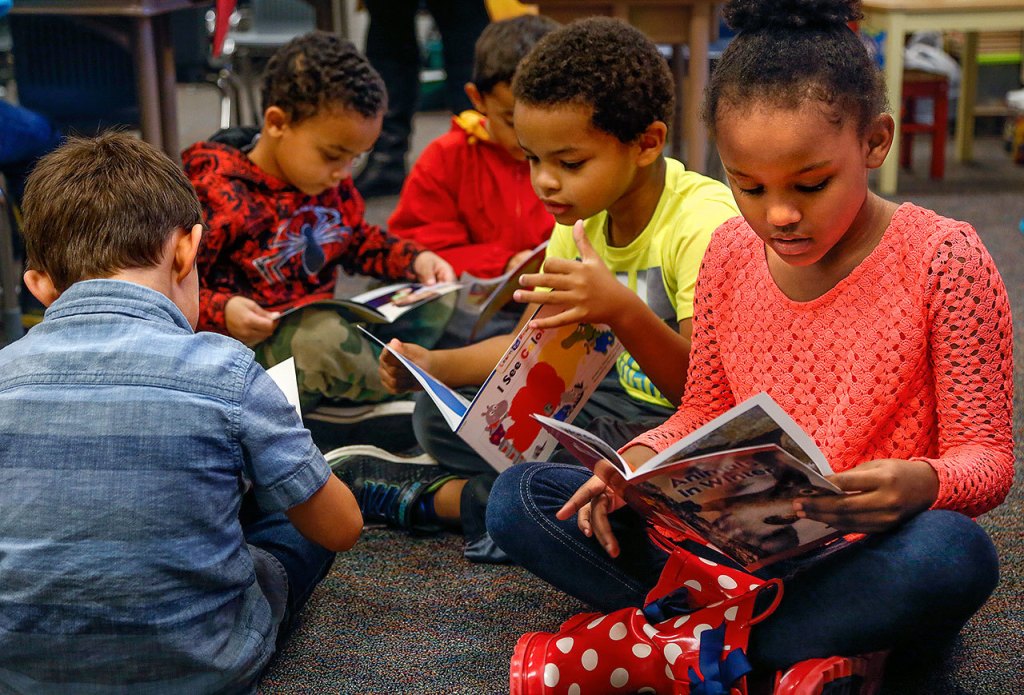 Kindergarteners (from left) Asher Wheatley, Quentin Cook, Iokua Baker, Elijah Stewart and Cai Williams-Smith dive right into the new books. The books are part of a $35,000 gift of supplies from Inspirus Credit Union to the Edmonds School District. (Dan Bates / The Herald)