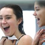 Monroe&rsquo;s Payton Leidholm shares a laugh with Mari Hsieh during warm-ups for the district dive prelims Wednesday at Snohomish Aquatic Center. (Kevin Clark / The Herald)