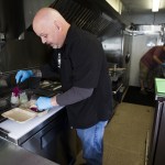Paul Welling (left) and Kyle Gourlie work inside Gourlie&rsquo;s Vet Chef food truck in Everett on Friday, Nov. 4. (Ian Terry / The Herald)
