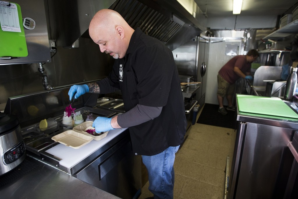 Paul Welling (left) and Kyle Gourlie work inside Gourlie&rsquo;s Vet Chef food truck in Everett on Friday, Nov. 4. (Ian Terry / The Herald)
