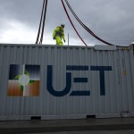 PUD workers unclip fasteners from a crane after placing a vanadium flow battery in place at the Everett Substation. The twenty newly installed batteries are scheduled to go live in March. (Ian Terry / The Herald)
