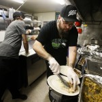 Randy Orsborn (right) dishes up a plate of smoked turkey at The Hawks Nest in Darrington on Thursday, Nov. 24. (Ian Terry / The Herald)