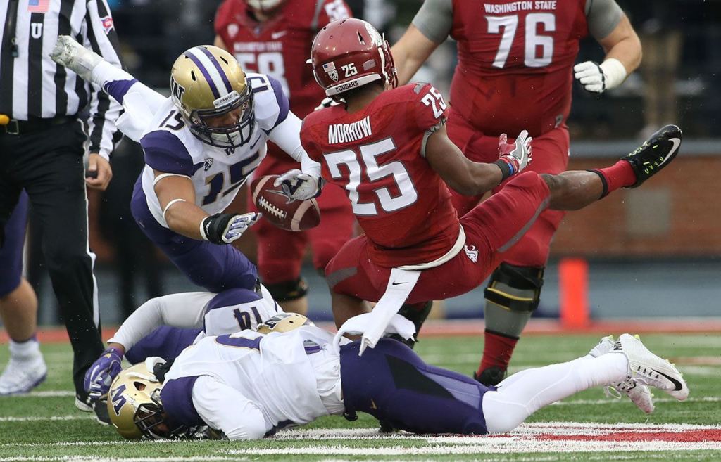 Washington State University&rsquo;s Jamal Morrow fumbles the ball as Washington linebacker DJ Beavers recovers during the fist half of the Apple Cup on Friday in Pullman. (Andy Bronson / The Herald)