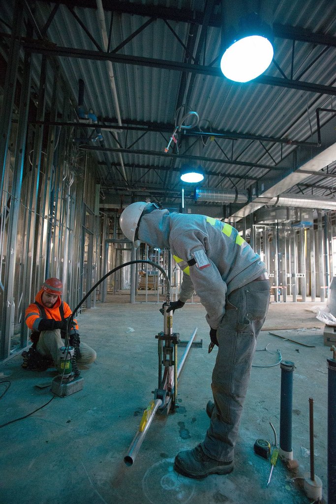 Workers bend a pipe under solar tube skylights the new Lakewood High School on Tuesday, Nov. 22, 2016 in Lakewood, Wa. (Andy Bronson / The Herald)