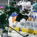 Everett&rsquo;s Wyatte Wylie checks Red Deer&rsquo;s Grayson Pawlenchuk with Everett&rsquo;s Riley Sutter closing during a game Wednesday night at Xfinity Arena in Everett. (Kevin Clark / The Herald)