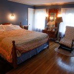 The master bedroom has an open wood floor and antique light fixtures. (Ian Terry / The Herald)