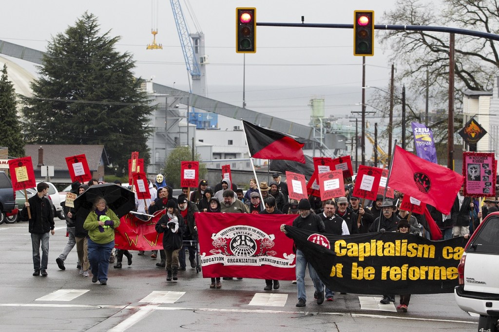 Industrial Workers of the World members walk along Hewitt Avenue in downtown Everett during a march Saturday afternoon to remember the victims of the 1916 Everett Massacre. (Ian Terry / The Herald)