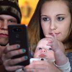 Jacob Varnes (left) looks over the shoulder of Jessiana King and his son Brayden Varner at her home in Granite Falls. (Kevin Clark / The Herald)