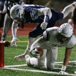 Peninsula&rsquo;s Kenny Easton reaches across the goal line for a touchdown with Meadowdale&rsquo;s Jackson Foltz attempting a stop during a 3A state quarterfinal game Friday at Edmonds Stadium. (Kevin Clark / The Herald)