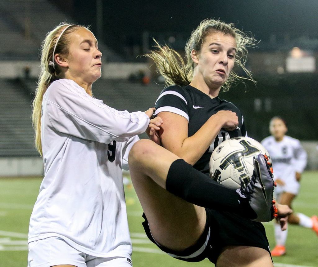Jackson&rsquo;s Bryn Matheson defends Kamiak&rsquo;s Jamie Beirne&rsquo;s attempt to gather the ball during a district soccer match Thursday night Everett Memorial Stadium. (Kevin Clark / The Herald)