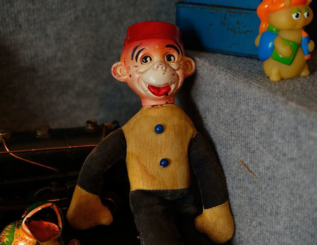 An unknown toy from the past peers from the shadows of a display in the Edmonds Historical Museum&rsquo;s &ldquo;Once Upon a Toy&rdquo; exhibit. (Dan Bates / The Herald)
