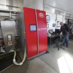 Larry Stap, owner of Twin Brook Creamery, looks over computer data as two cows are milked by automated milking machines at his dairy on Sept. 21 in Lynden. (Andy Bronson / The Herald)