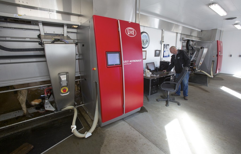 Larry Stap, owner of Twin Brook Creamery, looks over computer data as two cows are milked by automated milking machines at his dairy on Sept. 21 in Lynden. (Andy Bronson / The Herald)