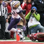 Washington running back Lavon Coleman crosses the goal line for a touchdown with Washington State&rsquo;s Charleston White trailing during the Apple Cup on Friday in Pullman. (Kevin Clark / The Herald)