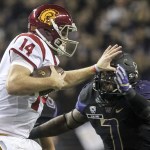 Southern California quarterback Sam Darnold stiff-arms Washington linebacker Keishawn Bierria for extra yardage Saturday night at Husky Stadium in Seattle. (Kevin Clark / The Herald)