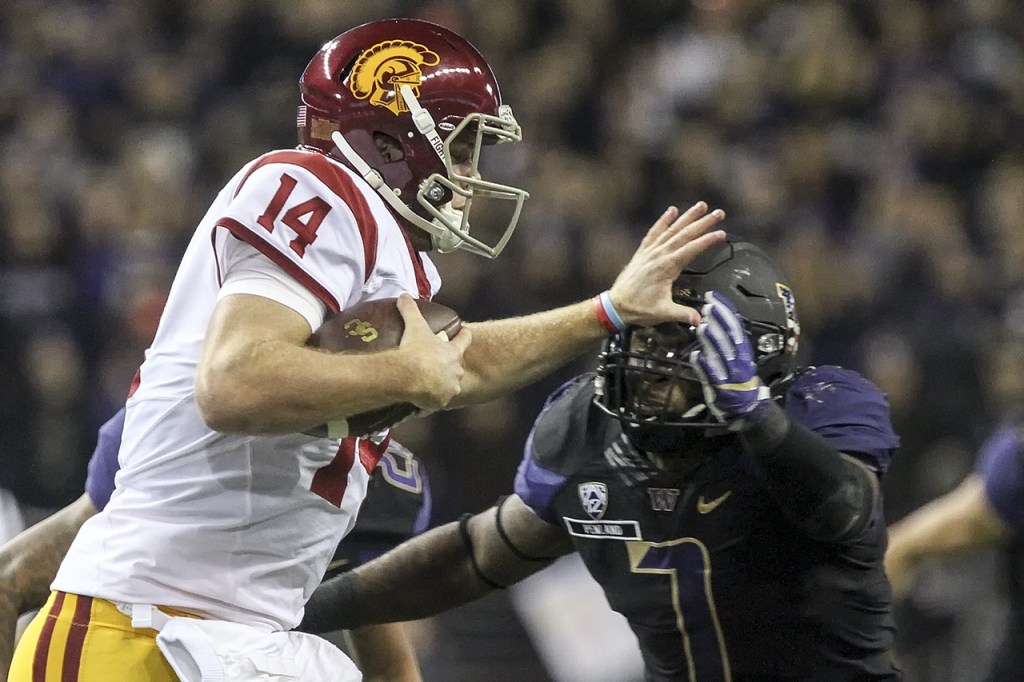 Southern California quarterback Sam Darnold stiff-arms Washington linebacker Keishawn Bierria for extra yardage Saturday night at Husky Stadium in Seattle. (Kevin Clark / The Herald)