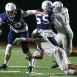 Meadowdale&rsquo;s Drew Tingstad is sacked by Peninsulas Braeden Potter during a 3A state quarterfinal game Friday at Edmonds Stadium. (Kevin Clark / The Herald)