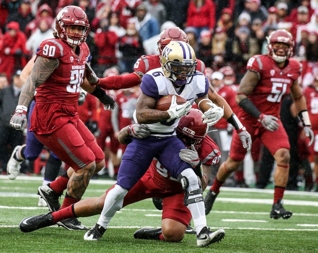 Washington wide receiver Chico McClatcher rushes toward the end zone with Washington State&rsquo;s Hunter Mattox attempting a tackle during the Apple Cup on Friday in Pullman. (Kevin Clark / The Herald)