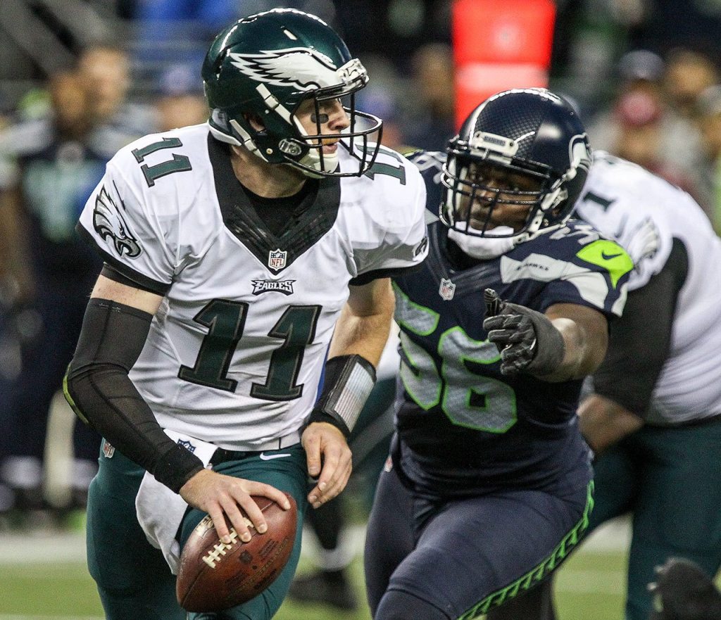 Eagles quarterback Carson Wentz is chased out of the pocket by Seahawks defensive lineman Cliff Avril Sunday afternoon at CenturyLink Field in Seattle on November 20, 2016. Seahawks won 26-15. (Kevin Clark / The Herald)
