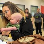 Jessiana King holds her son, Brayden Varnes, during a lunch period at Crossroads High School in Granite Falls. Crossroads offers childcare and King spends every lunch with Brayden and friends. (Kevin Clark / The Herald)