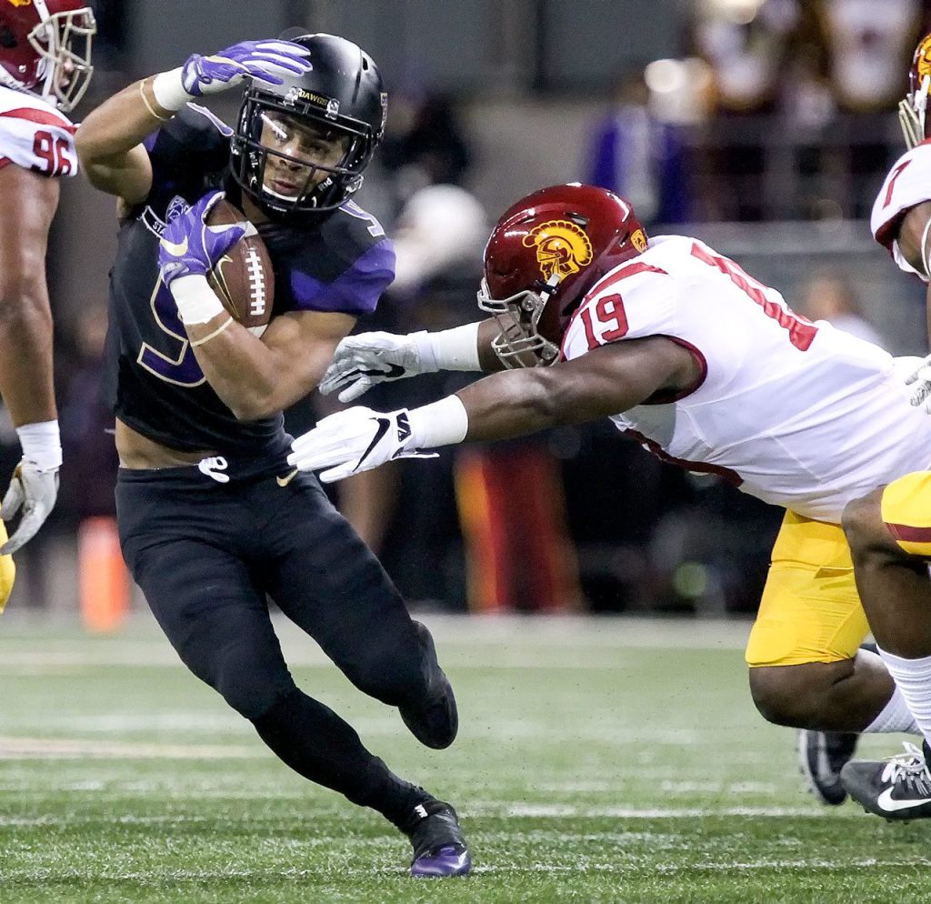 Washington running back Myles Gaskin works to avoid a tackle attempt by Southern California linebacker Michael Hutchings Saturday night at Husky Stadium in Seattle on November 12, 2016. (Kevin Clark / The Herald)