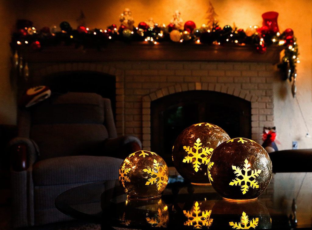 Lighted Christmas balls reflect on a glass table in the cozy family room at the Jubie house. (Dan Bates / The Herald)