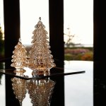 Framed by glass windows, glass trees stand reflecting on a glass table top in the Jubie home. (Dan Bates / The Herald)