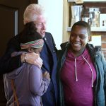 Former President Bill Clinton hugs Jordan Queen (left), 12, and her mother, Patrice Brown, 36, both of Detroit, inside the Germack Coffee Roasting Co. in Detroit on Thursday, prior to his wife&rsquo;s campaign visit Friday afternoon. (Todd McInturf / The Detroit News)