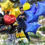 A woman leaves balloons at a make-shift memorial for slain San Antonio police officer Benjamin Marconi, 50, a 20-year veteran of the force, Monday, Nov. 21, in San Antonio. Marconi was fatally shot during a traffic stop near police headquarters Sunday. (AP Photo/Eric Gay)