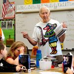 James Henry (back left) looks in one of the new dictionaries while Jack Lapoint (center) tells Silver Lake Elementary School third-graders in Christi Castro&rsquo;s class about some of the amazing information available in a dictionary, after the two Kiwanis Club members gave them new dictionaries. It was the final dictionary giveaway by the organization, which recently voted to disband because there aren&rsquo;t enough members. (Dan Bates / The Herald)