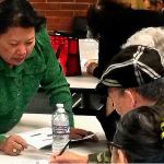 Van Dinh-Kuno (left), executive director of Refugee and Immigrant Services Northwest, answers questions about the general election ballot at an event sponsored by the Asian Pacific Islander Coalition on Friday at Everett Community College. Participants were U.S. citizens needing help from interpreters before casting their votes. (Julie Muhlstein / The Herald)
