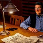 Frank Melder Jr, 77, shares what he knows about his grandfather Charles Curtiss, the National Guard lieutenant killed in the Everett Massacre, and what became of his grandmother after the Nov. 5, 1916, shootings. In the background is Camano Island artist Jack Gunter&rsquo;s painting &ldquo;The Everett Massacre,&rdquo; now on loan to the Everett Public Library. (Dan Bates / The Herald)